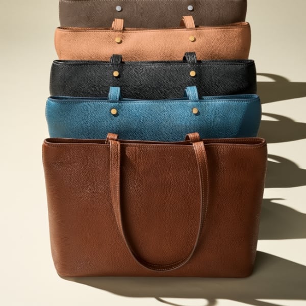 Five Jessie tote bags in brown leather, blue leather, black leather, light brown leather and dark brown leather.