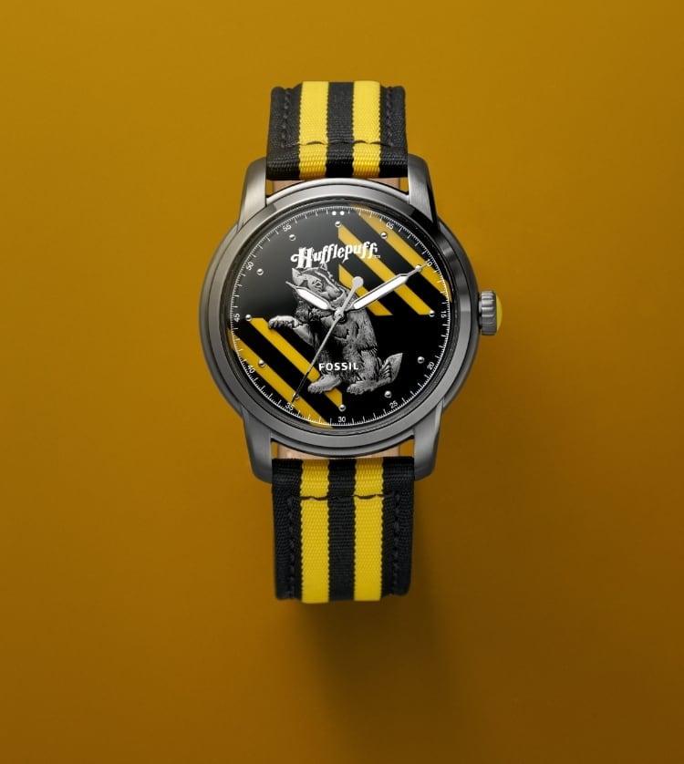 Silver-tone Hufflepuff house watch with a black and yellow strap and a gold-tone Hufflepuff house pendant.