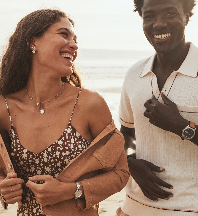 Summer Starts Now. Two people standing on a beach wearing new styles from the summer collection.