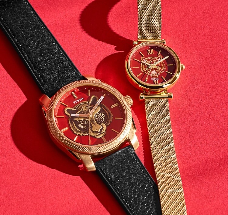 Une montre en cuir, brune, avec un tigre sur le cadran et une montre en maille, dorée, avec un tigre sur le cadran. Motifs du Nouvel An lunaire