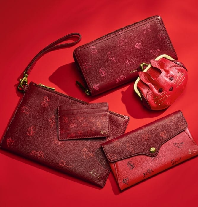 Five red women’s leather accessories with different animals from the Chinese Zodiac printed on them.