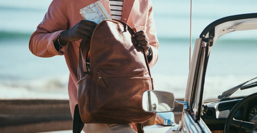 A man wearing a brown leather Buckner backpack.