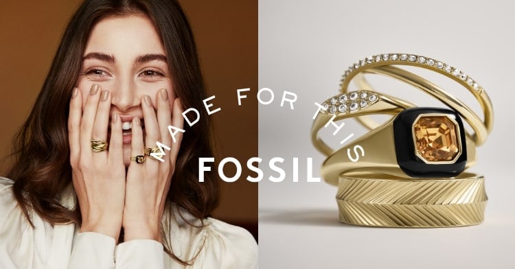 Made For This – Fossil. Eine lachende Frau, die mehrere goldfarbene Ringe trägt.