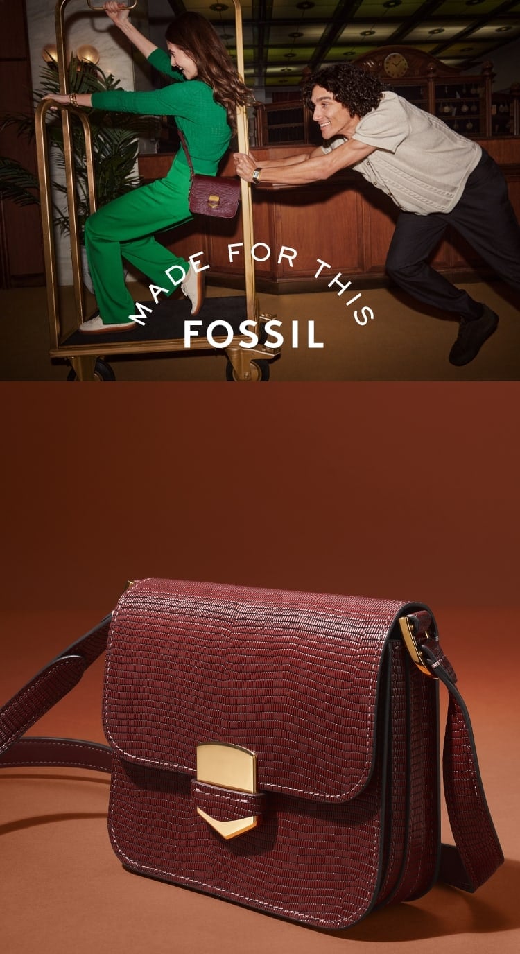 A woman in a green jumpsuit carrying the brown leather Lennox bag and being pushed on a hotel trolley cart by a man wearing the Carraway watch. Made For This Fossil. The brown leather Lennox bag.