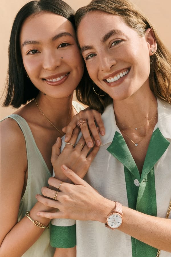 Zwei Models, die sich umarmen und Fossil Schmuck tragen.
