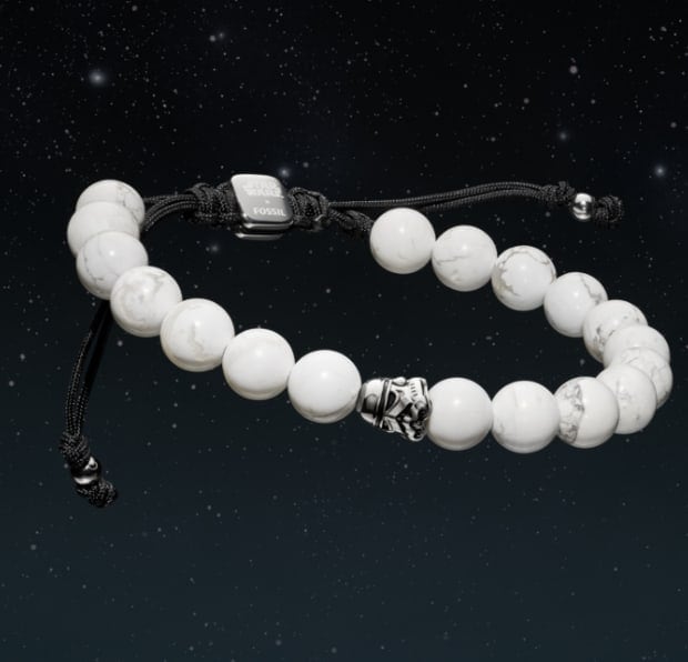 Un bracelet de perles blanches avec une perle représentant un casque de stormtrooper