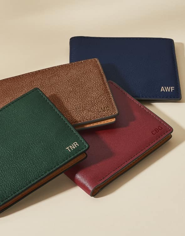 Four leather wallets. The top is embossed with TNR and the last is embossed with AWF.