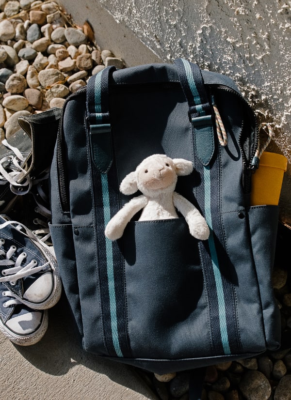 Sac à dos bleu pour homme avec un animal en peluche qui en sort.