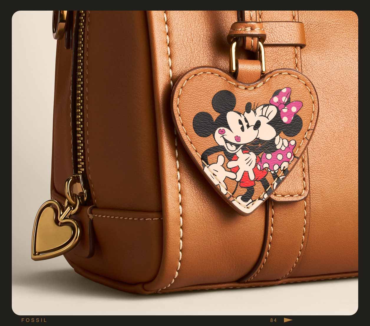 Primer plano del minibolso satchel Carlie de piel marrón, que luce un estampado repujado de Mickey Mouse y Minnie Mouse.