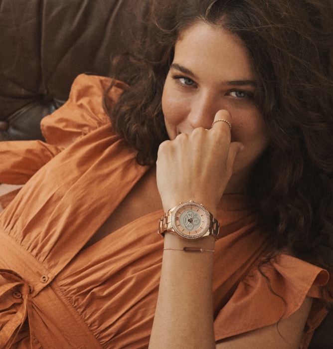 Woman wearing a rose gold-tone Gen 6 Hybrid smartwatch.