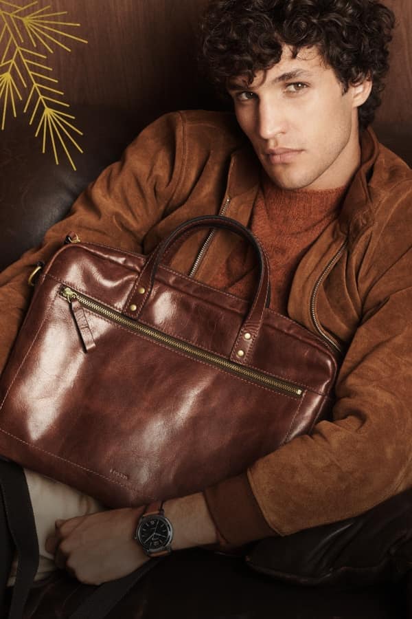 A man holding the brown leather Haskell workbag.