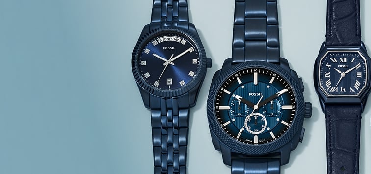 A kid in a white shirt and blue bucket hat sitting on a father's shoulders, with mother standing by – both adults are wearing navy blue Fossil watches. An assortment of five all-navy-blue Fossil watches.