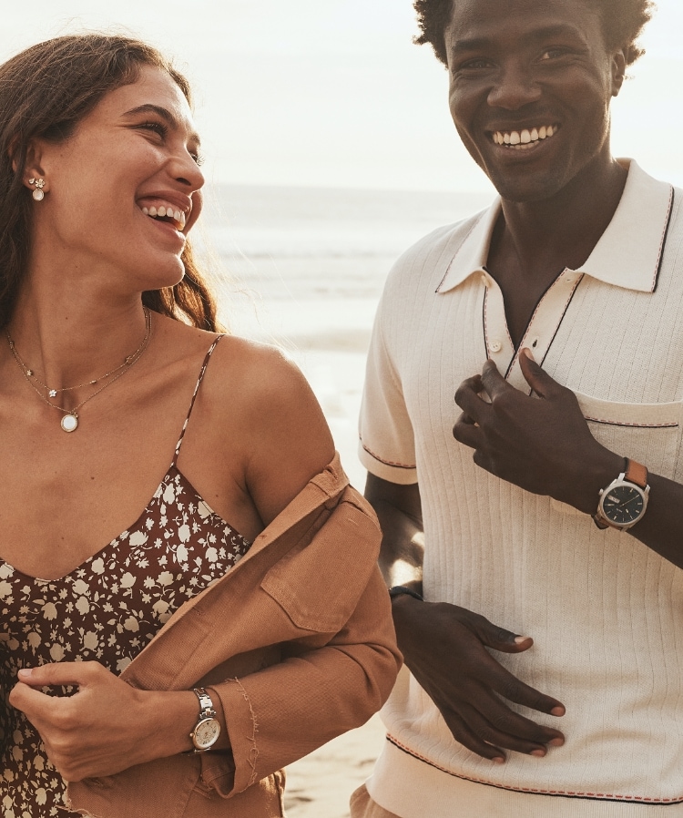 L’estate inizia ora. Un uomo e una donna indossano i nuovi modelli estivi e sorridono su una spiaggia.