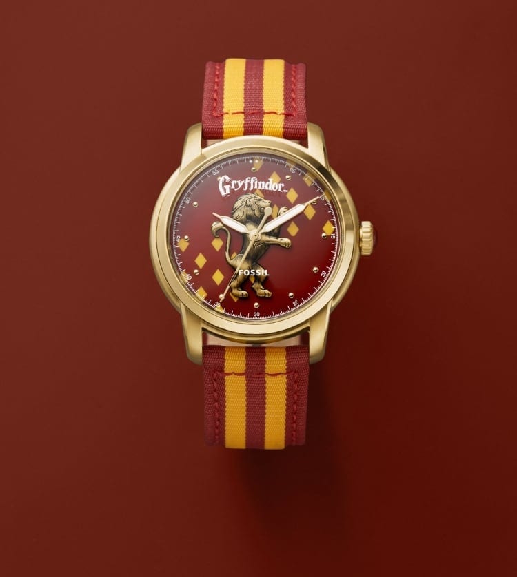 Gold-tone Gryffindor house watch with a red and gold strap and a gold-tone Gryffindor house pendant.