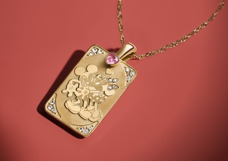 Collana di Topolino e Minnie con pendente color oro e dettagli in cristallo.