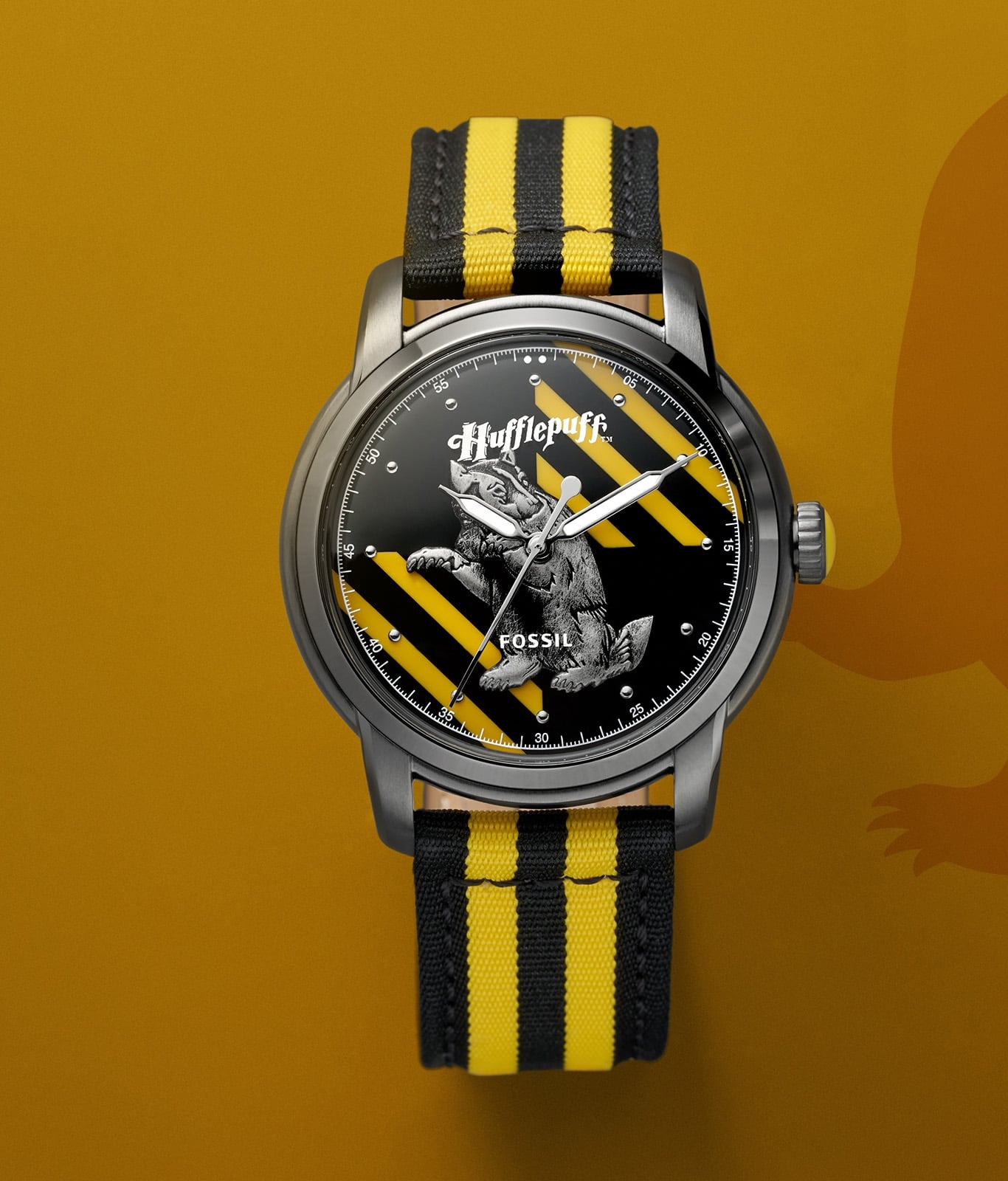 Montre argentée de la maison Poufsouffle avec un bracelet jaune et noir.