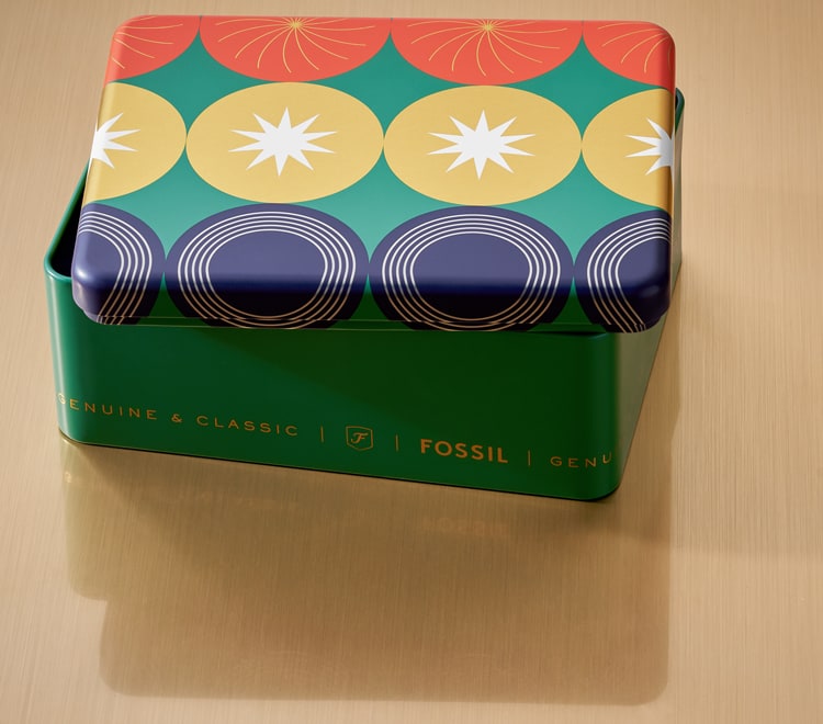 Gif of a brightly colored Fossil gift set tin opening to reveal a men's brown leather watch and brown leather bracelet.