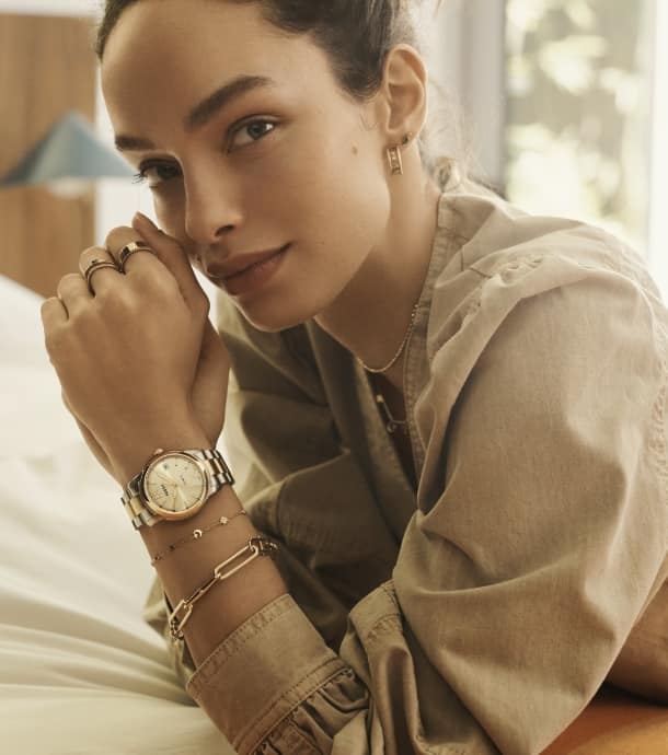 A woman wearing a two-tone Fossil Heritage watch.