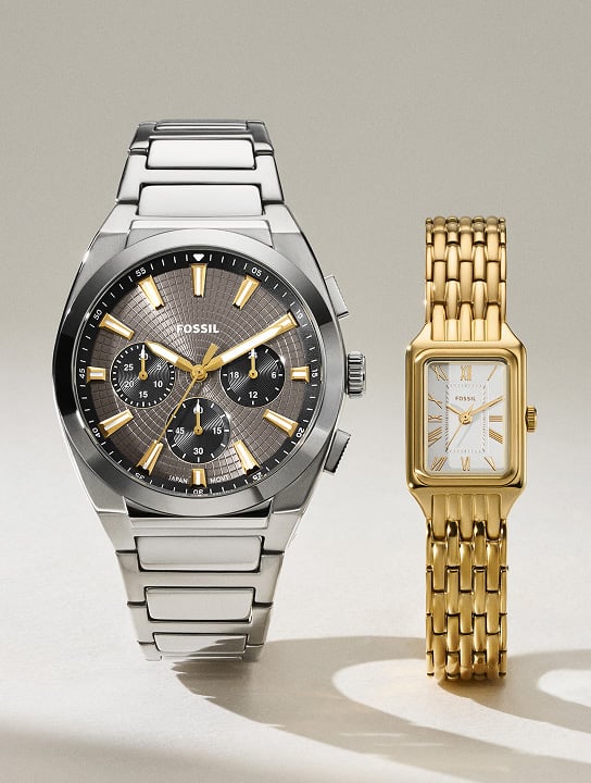 The Fossil gold-tone Raquel Mini watch shown alongside the Fossil Everett watch, featuring a smoky blue dial and silver-tone finish.