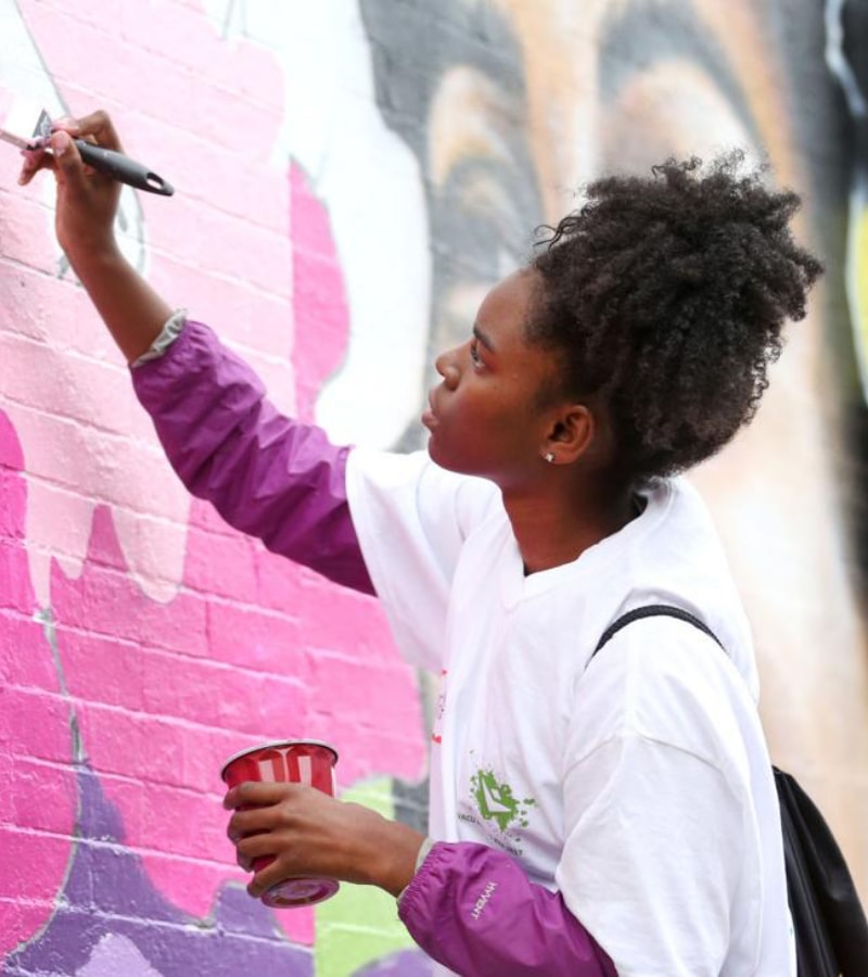A young woman painting a mural A young woman painting a mural