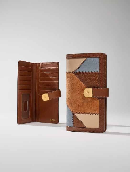 A heart-embossed brown bifold wallet displaying a photo inside.