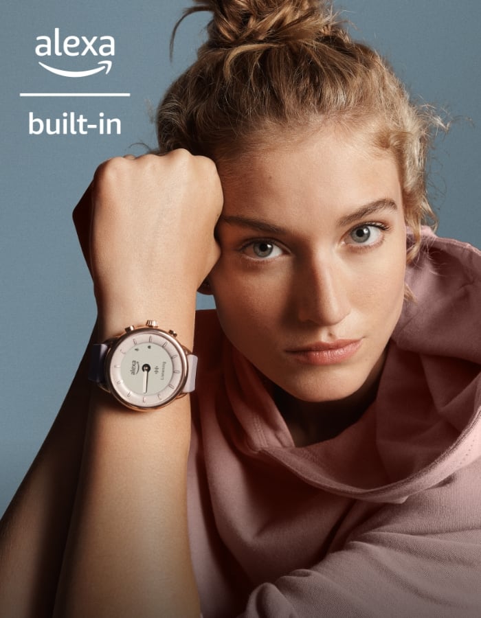 Une femme portant un sweat rose et une montre connectée hybride Gen 6 édition Wellness.