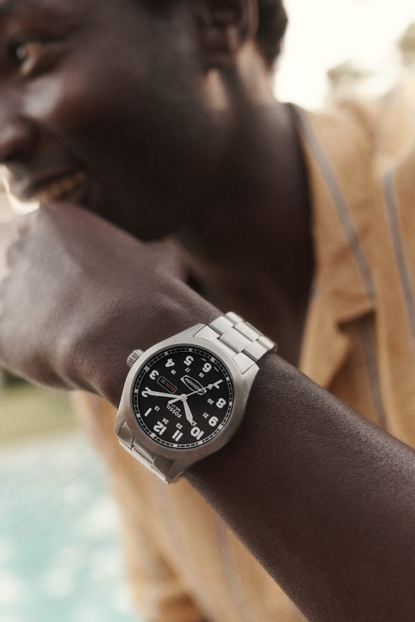 A man wearing a stainless steel Defender watch.