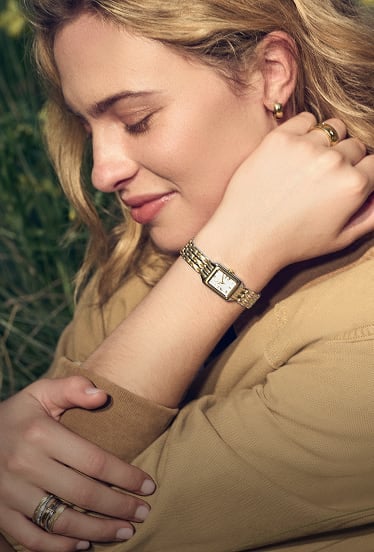 A lifestyle image of a woman wearing the watch in a spring meadow.