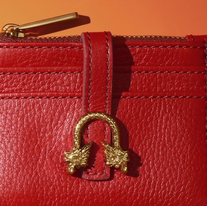 Red leather wallet with gold-tone dragon hardware.