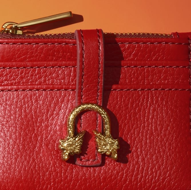 Red leather wallet with gold-tone dragon hardware.