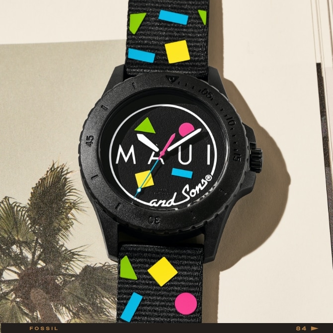 La montre FB-01 solaire avec le logo Maui and Sons sur un fond agrémenté de palmiers.
