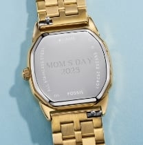 Le dos du boîtier d’une montre dorée.