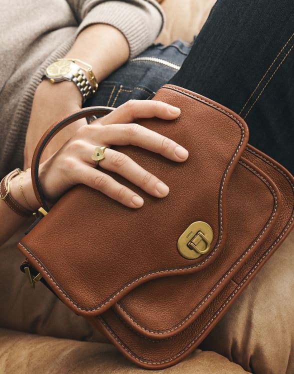 Close-up shot of a woman holding a Fossil Heritage handbag.