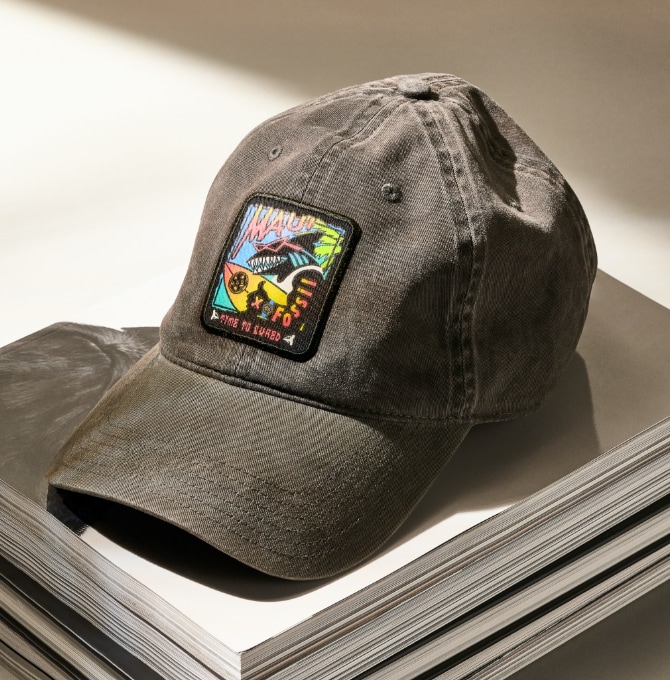 Le chapeau personnalisé Maui and Sons x Fossil est caractérisé par un requin ainsi que des imprimés et couleurs inspirés des années 80.