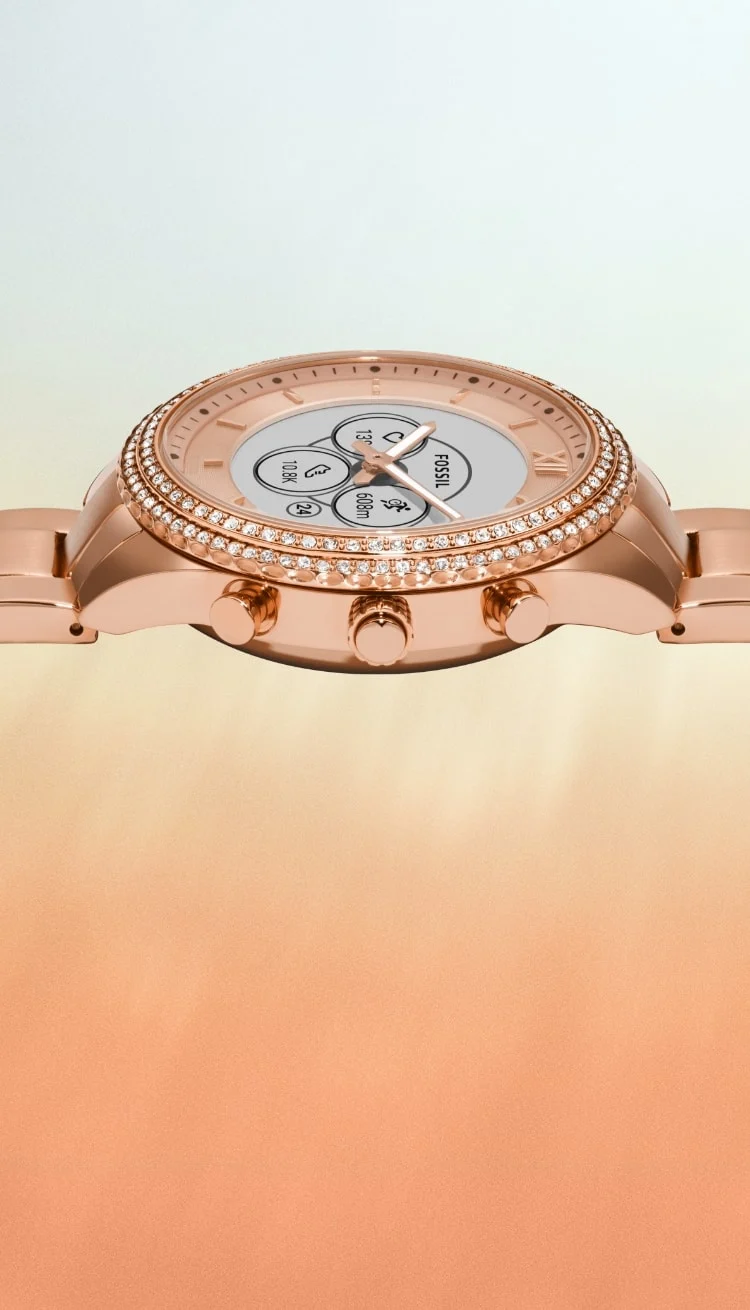 A closeup of the rose gold-tone Gen 6 Hybrid smartwatch with a dial displaying a notification to attend a party.