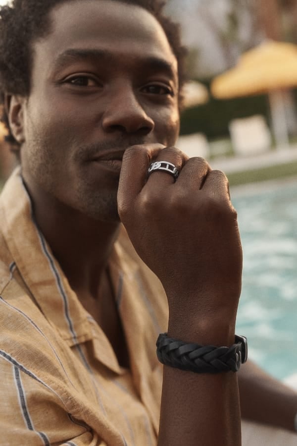 Un uomo che indossa i gioielli primaverili di Fossil. 