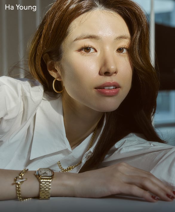 A couple lounging in the grass, each wearing Fossil watches.