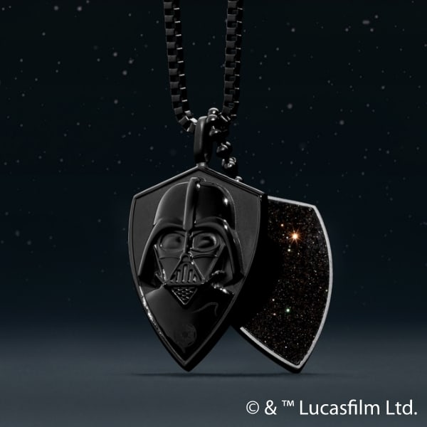 A black dog tag style necklace with a relief of Darth’s helmet